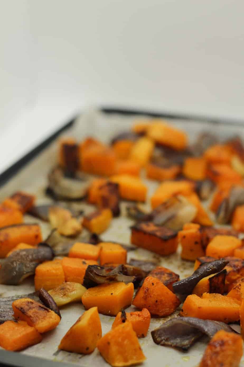Roasted butternut squash on a baking sheet lined with parchment paper.