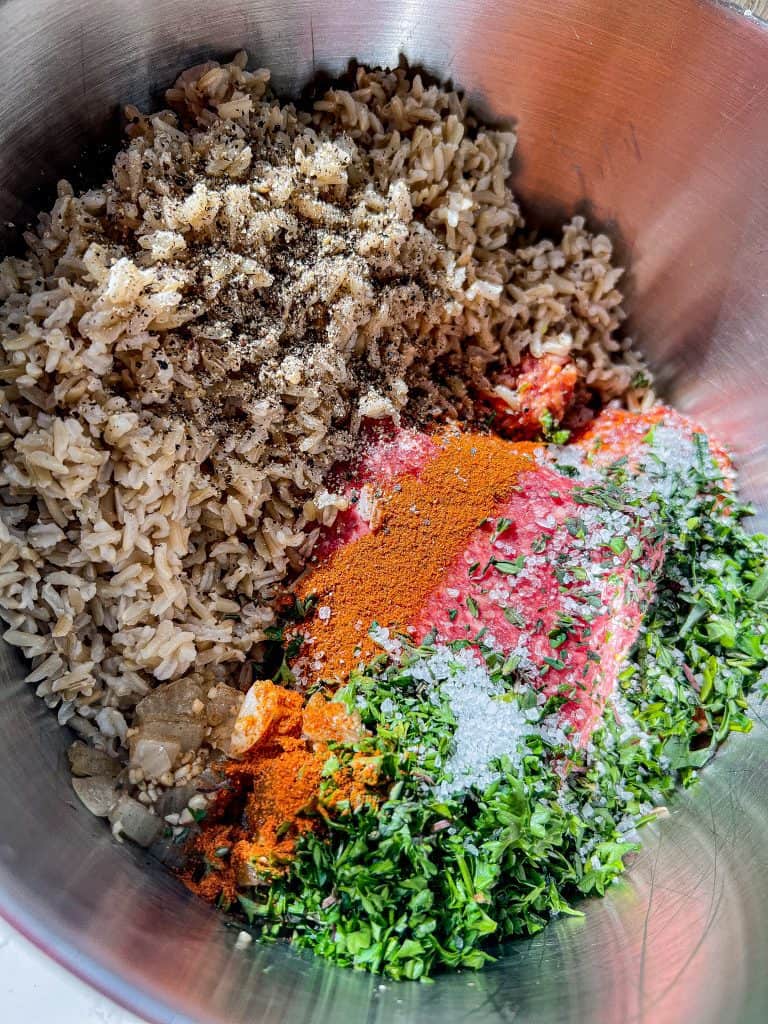 bowl of raw pork and beef, parsley, tarragon, thyme, onion, fresh garlic, hot Hungarian paprika, and cooked rice