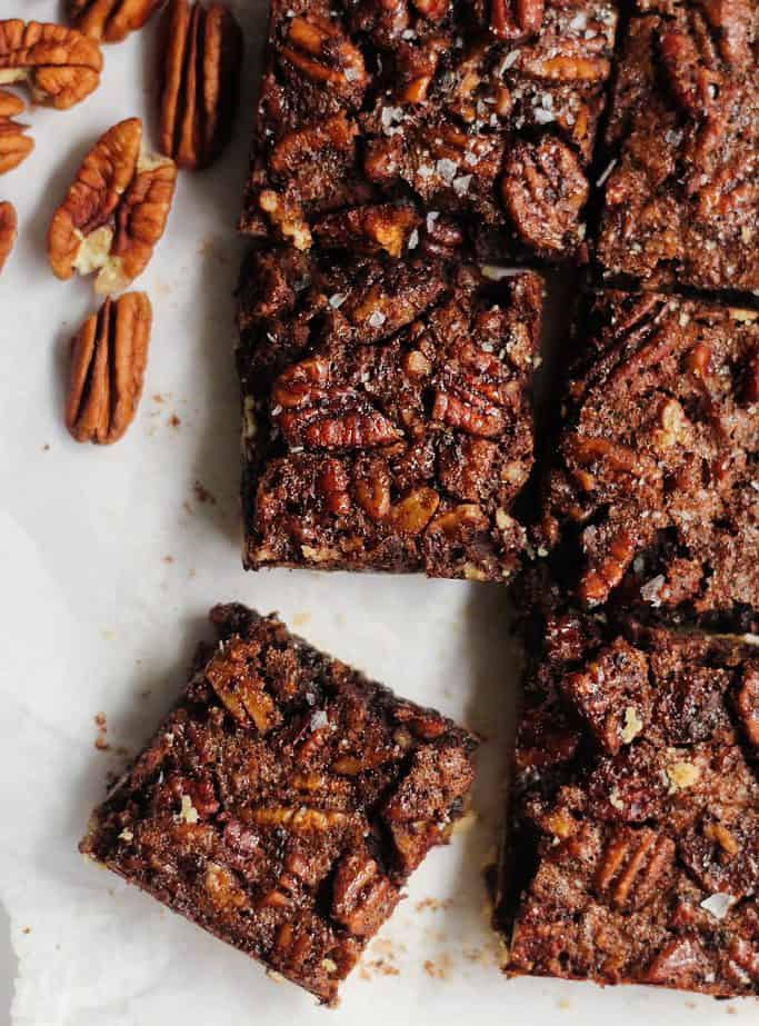 Pecan shortbread bars cut into squares on a piece of parchment paper.