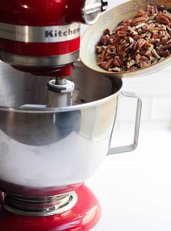 Pecans being dumped into the kitchenaid with the pecan shortbread bars batter.