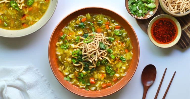Two bowls of chicken Manchow Soup on a white surface.