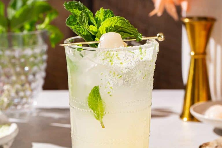 Lychee mocktail with a salted rim and garnished with mint.