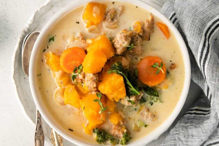 Butternut squash chili in a white bowl with a gray black and white napkin.