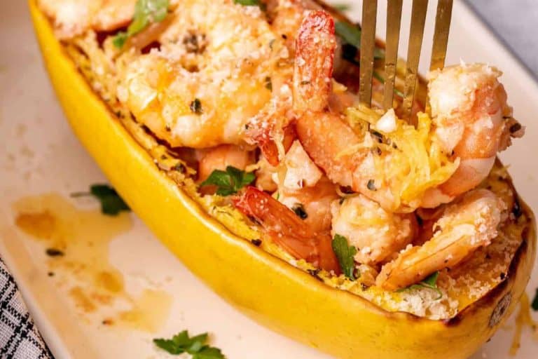Spaghetti squash stuffed with shrimp scampi on a white plate.