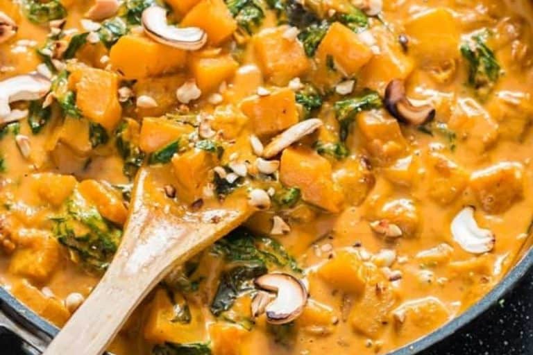 Thai butternut squash curry with a wooden spoon fall dishes for dinner.