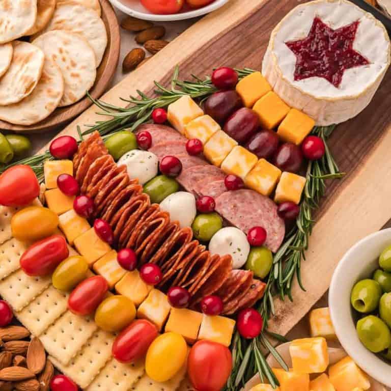 Christmas appetizers tree Charcuterie Board with cheese, rosemary, cherry tomatoes, meats, olives, etc.